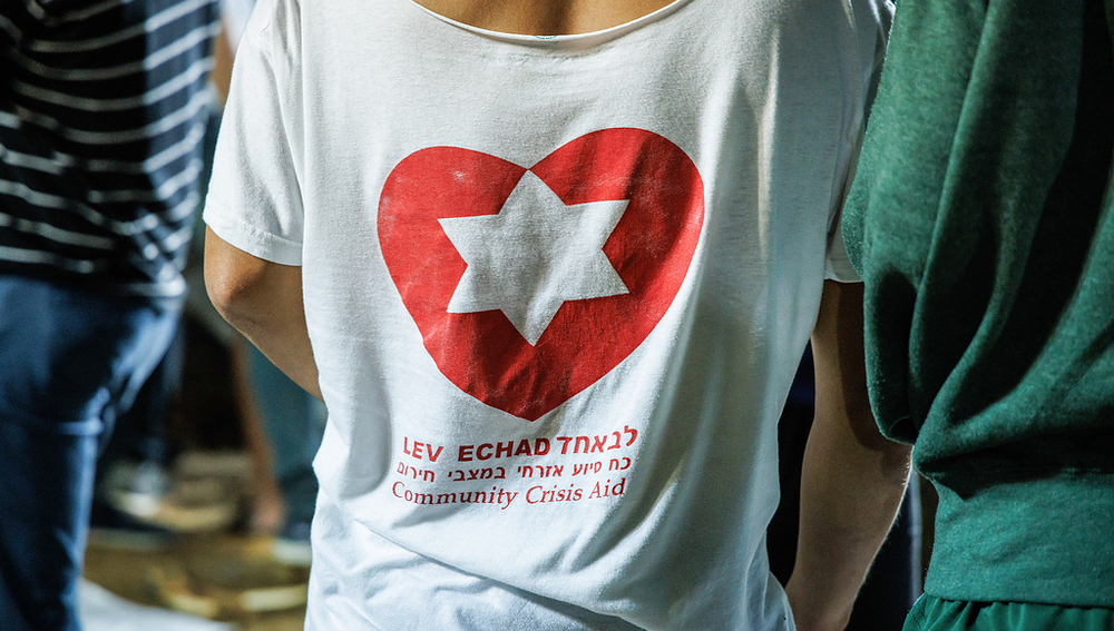 Ein freiwilliger Totengräber trägt T-Shirt mit der Aufschrift 'Lev echad' (dt. ein Herz) und darüber ein Herz mit einem Davidstern, auf dem nationalen Militärfriedhof auf dem Herzlberg in Jerusalem (Israel) am 11. Oktober 2023.